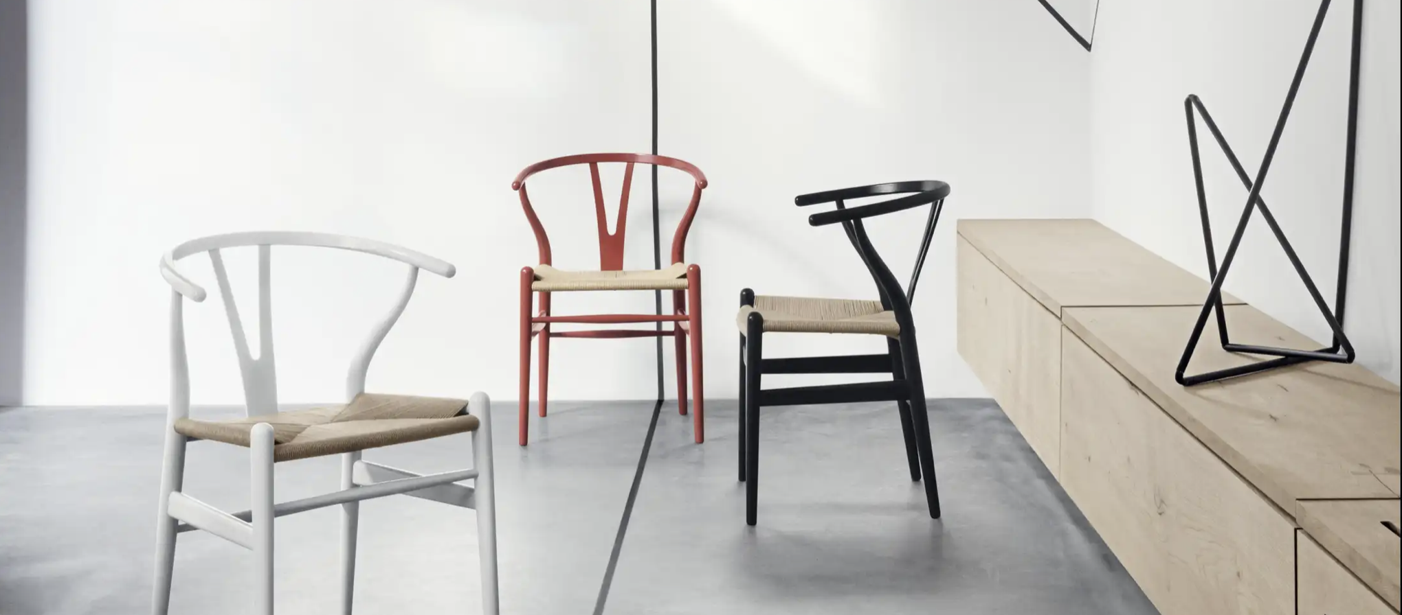 Drei Designstühle in einem modernen, minimalistischen Raum