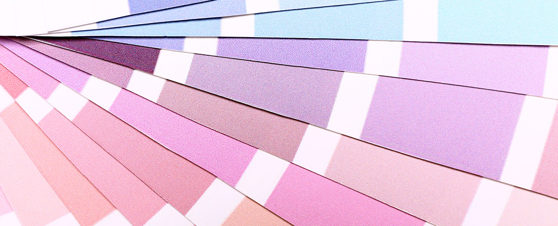 Farbmusterfächer mit verschiedenen Pastelltönen in Rosa, Lila und Blau zur Auswahl für Wandfarbe oder Design.